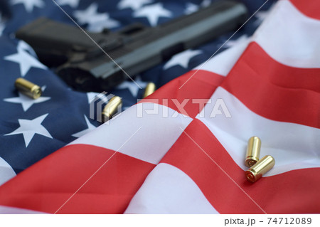 9mm bullets and pistol lie on folded United States flag 9mm bullets and pistol lie on folded United States flag 74712089