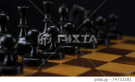 Black chess pieces on a chessboard. An army of black pawns on the table Black chess pieces on a chessboard. An army of black pawns on the table 74712281