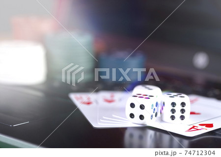 Online gaming platform, casino and gambling business. Cards, dice and multi-colored game pieces on laptop keyboard Online gaming platform, casino and gambling business. Cards, dice and multi-colored game pieces on laptop keyboard 74712304
