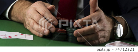 Businessman at green playing table with gambling chips and cards playing poker and blackjack in casino Businessman at green playing table with gambling chips and cards playing poker and blackjack in casino 74712321