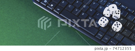 Online gaming platform, casino and gambling business. Dice on laptop keyboard on green background 74712355
