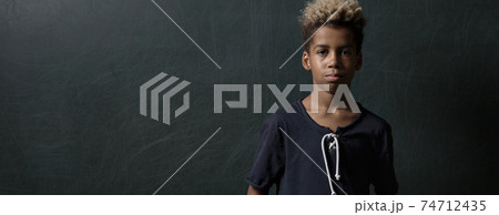 Mixed-race schoolboy pose on black background 74712435