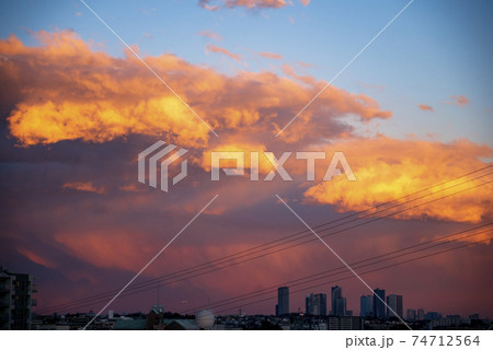 冬の午後東京上空に現れた奇怪な赤い雲の写真素材