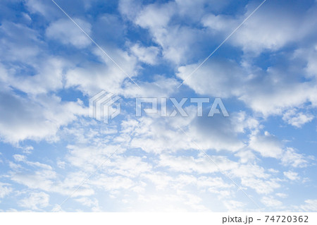 背景 素材 青空と広がる白い雲 朝日の光の写真素材 [74720362] - PIXTA