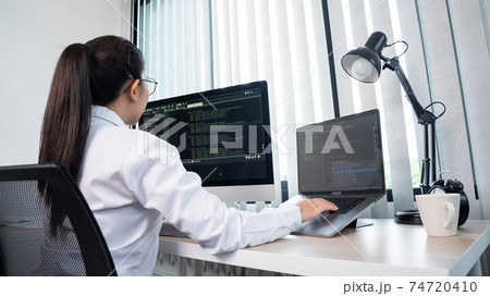 Young Asian woman Programmer Typing code working with computer at table, coding cyberspace and Web Development Concept 74720410