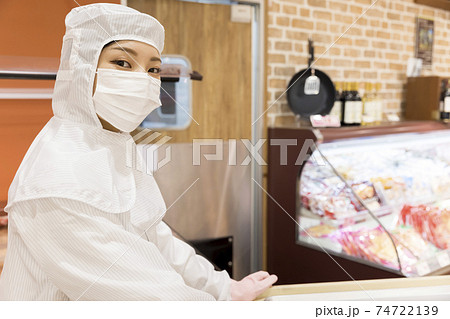 スーパーで衛生着を着てお惣菜用カートを押す女性店員 74722139