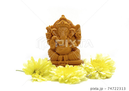 Ganesha statue of Hindu god with flowers on white background. Ganesha statue of Hindu god with flowers on white background. 74722313