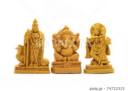 The hand-carved wooden idol of Lord Murugan with Radha Krishna and Ganesha is isolated on a white background The hand-carved wooden idol of Lord Murugan with Radha Krishna and Ganesha is isolated on a white background 74722325