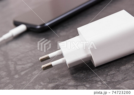 Smartphone with connected plug of charger. Telephone charging Smartphone with connected plug of charger. Telephone charging 74723200