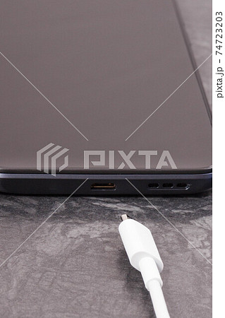 Black mobile phone and unconnected cable of charger. Smartphone charging Black mobile phone and unconnected cable of charger. Smartphone charging 74723203