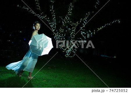 雨模様の夜の公園に立つハーフの女性 74725052