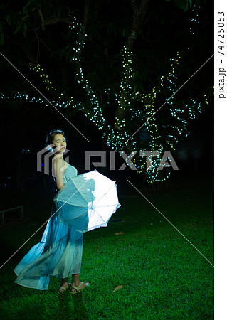 雨模様の夜の公園に立つハーフの女性 雨模様の夜の公園に立つハーフの女性 74725053