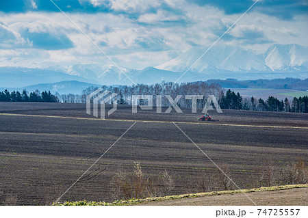 春の畑とトラクターでの農作業 74725557
