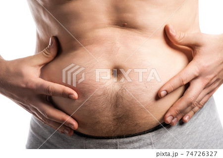 The man stuck out out his stomach and touches it with his hands The man stuck out out his stomach and touches it with his hands 74726327