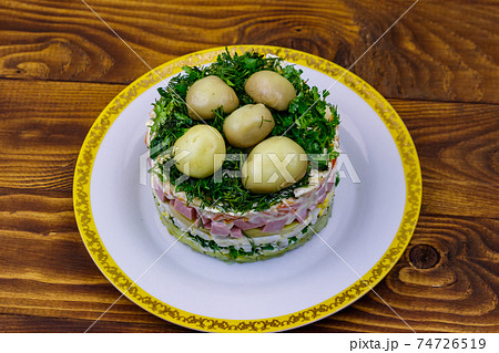 Traditional Russian layered salad "Mushroom Glade" from boiled potatoes, carrots, eggs, sausage, soft cheese, marinated mushrooms and mayonnaise on wooden table Traditional Russian layered salad "Mushroom Glade" from boiled potatoes, carrots, eggs, sausage, soft cheese, marinated mushrooms and mayonnaise on wooden table 74726519