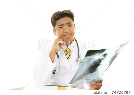 レントゲン写真を持つ不安そうな表情の医師 74726797