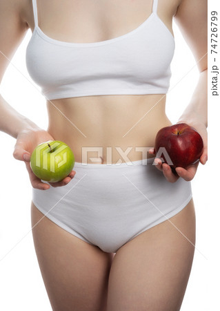A female holding a red and green apples in different arms isolated on white background. A female holding a red and green apples in different arms isolated on white background. 74726799
