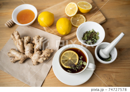 Cup of ginger tea with lemon on wooden table Cup of ginger tea with lemon on wooden table 74727578
