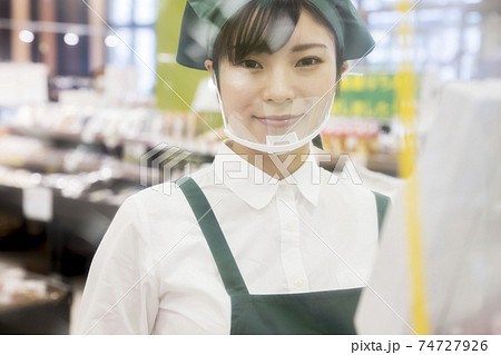 感染対策をしたスーパーのレジで仕事をする女性従業員 シート越し 感染対策をしたスーパーのレジで仕事をする女性従業員 シート越し 74727926