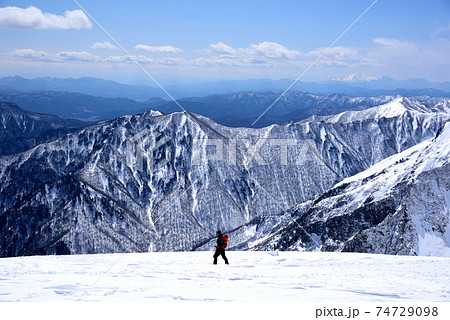 残雪期の上信越の山並みを眺めがなら谷川岳天神尾根を下る登山者 残雪期の上信越の山並みを眺めがなら谷川岳天神尾根を下る登山者 74729098