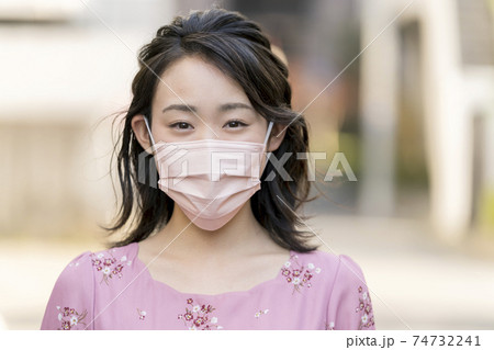 ピンクの不織布マスクをつけた20代の女性 74732241