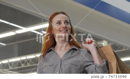 Attractive woman looking around in the mall while shopping 74733096