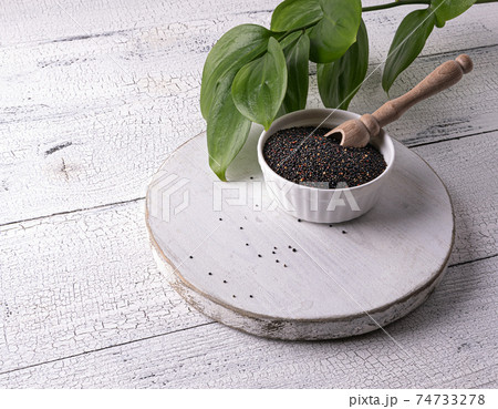 Black quinoa seeds and scoop in bowl on white table Black quinoa seeds and scoop in bowl on white table 74733278
