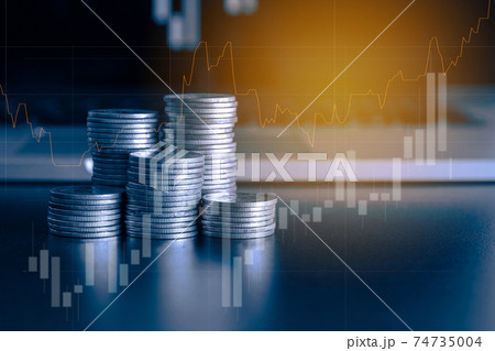 Stack of money coin and laptop computer with trading graph, financial investment concept with blue filter can be use as background 74735004