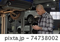 Handsome African man using smart phone at the garage 74738002