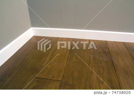 Close up of white plastic plinths on dark wooden oak floor parquet. 74738020