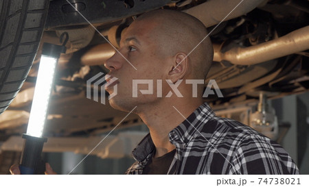 Cropped shot of a young male driver working at his garage 74738021