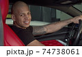 Cheerful handsome African man smiling to the camera while sitting in his car 74738061