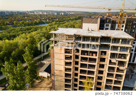 High multi storey residential apartment building under construction. Concrete and brick framing of high rise housing. Real estate development in urban area. 74738062