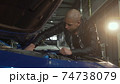Young handsome man repairing his car at the garage 74738079