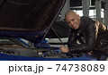Cheerful handsome African man smiling to the camera while working at his garage 74738089