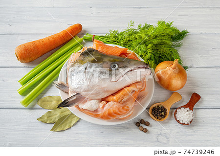 Raw ingredients for cooking fish stock: fresh salmon head and bones, vegetables, salt and pepper. 74739246