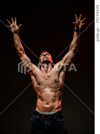 Handsome sexy man with muscular body pulls both Handsome sexy man with muscular body pulls both 74739335