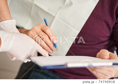 Patient signing the documents while sitting 74740916