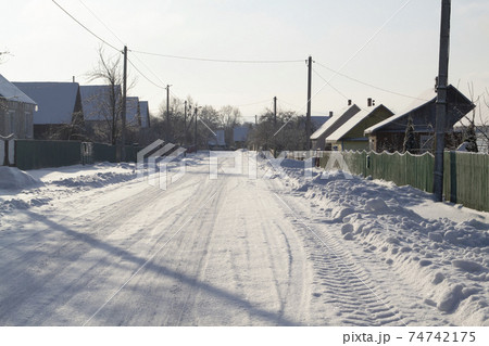 Winter rural road and trees in snow in Belarus Winter rural road and trees in snow in Belarus 74742175