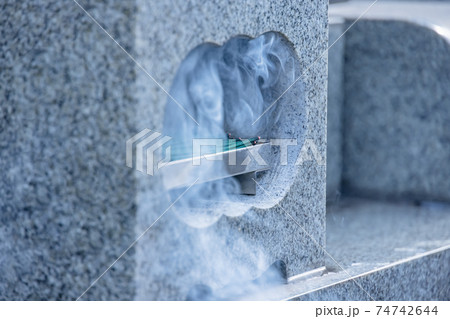 お墓に供えられたお線香 お墓に供えられたお線香 74742644