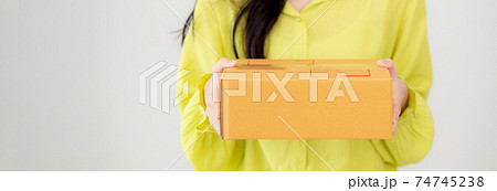 Young asian woman holding cardboard box at home, happy female carrying parcel box giving. 74745238