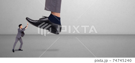 Foot of leader or boss with authority huge trample on frightened employee with bullying. 74745240