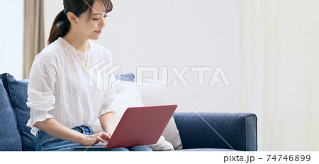リビングでノートパソコンを使う女性 リビングでノートパソコンを使う女性 74746899