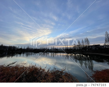 池の上空の雲から覗く青空 74747103