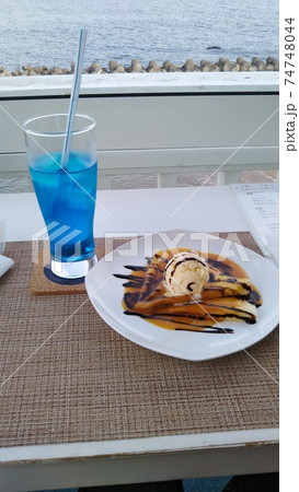 北海道の海をバックにしたパンケーキとジュースの写真 74748044