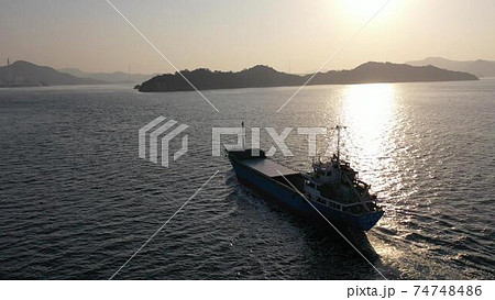 竹原市的場海水浴場沖を朝日を受けて航行する貨物船 74748486