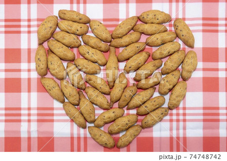 The cookies are spread out on the table in the shape of a heart 74748742