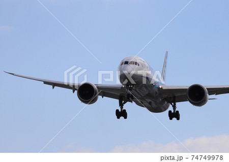 青空の中の旅客機の着陸シーン 74749978