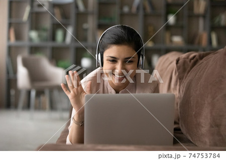 Smiling Indian woman talk on video call on computer Smiling Indian woman talk on video call on computer 74753784