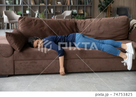 Exhausted Indian woman fall asleep on couch at home Exhausted Indian woman fall asleep on couch at home 74753825